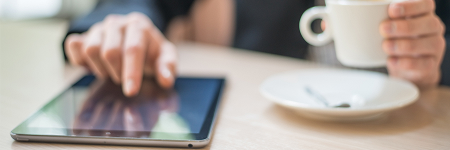 A man scrolls through the news on his tablet device