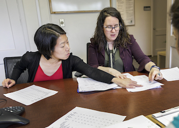 A graduate student in the 博彩网站-PSU School of Public Health reviews documents with a faculty mentor.