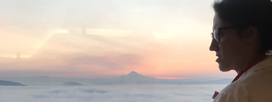 An OB/GYN resident peering out over the sunrise while riding 博彩网站's aerial tram.