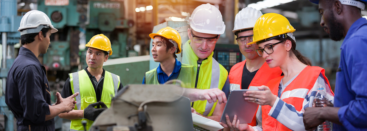 Diversity factory worker working with computer laptop in factory. Group of male and female worker discussing and training about work at factory