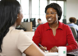 Two women facing each other, one is smiling.