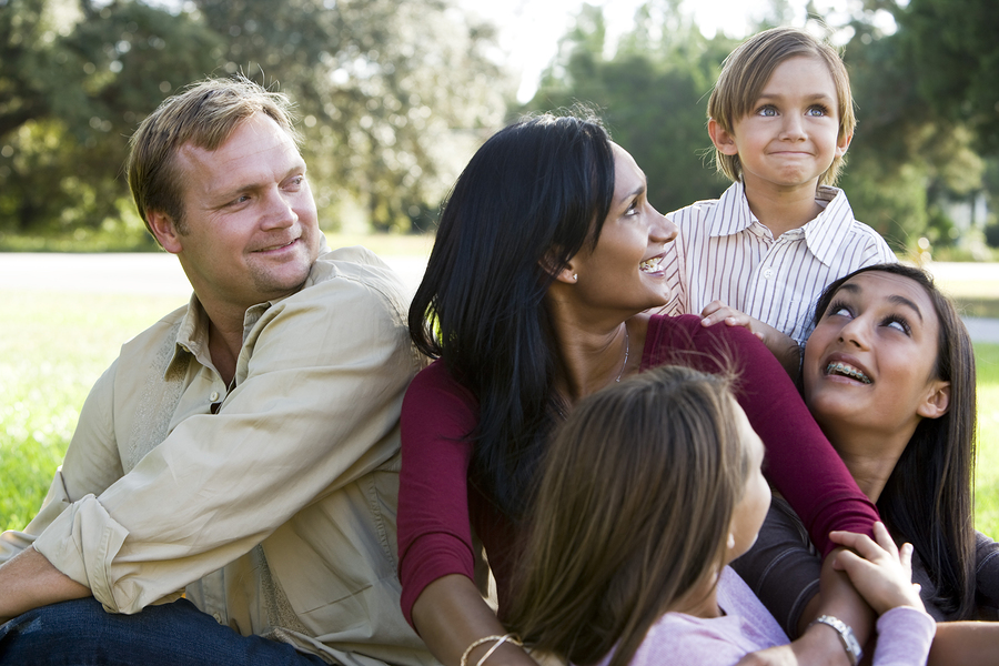 Family sitting close together on the grass