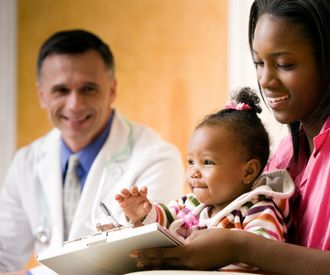 Male doctor next to a mother and baby