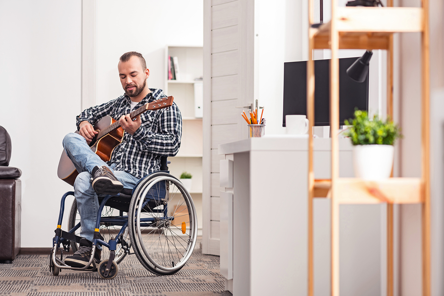 Man in a wheelchair, playing guitar