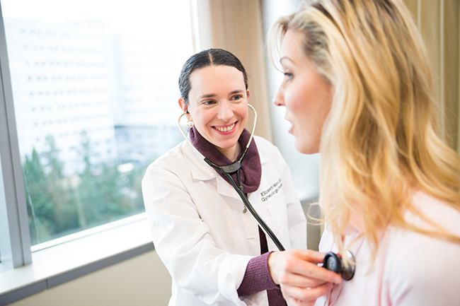 Dr. Elizabeth Munro, of the 博彩网站 Knight Cancer Institute listenting to a patient's heart beat.