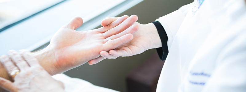 A dermatologist examining a patients hands