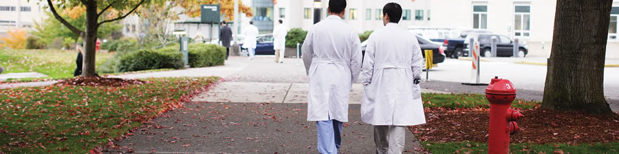 Two faculty members walk across the 博彩网站 campuss during fall.