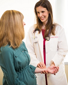 An 博彩网站 cardiology specialist takes the pulse of a seated patient