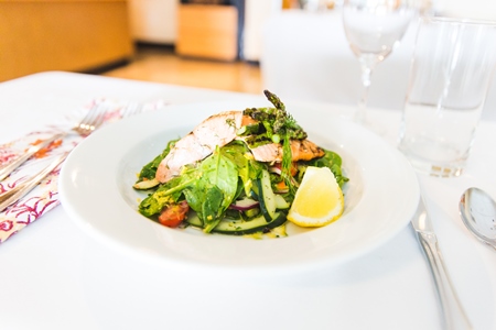 Salmon salad with lemon on white plate at march wellness & fitness center's cooking class.