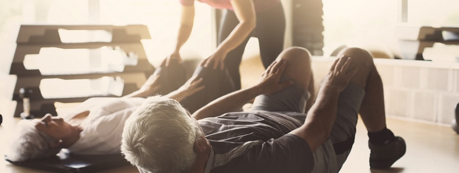 older people practicing exercises with an instructor