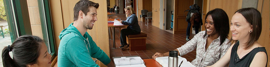 Students studying and laughing at a table