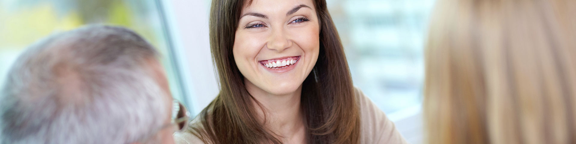 Person smiling at two other people