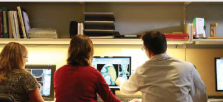 3 people looking at a computer