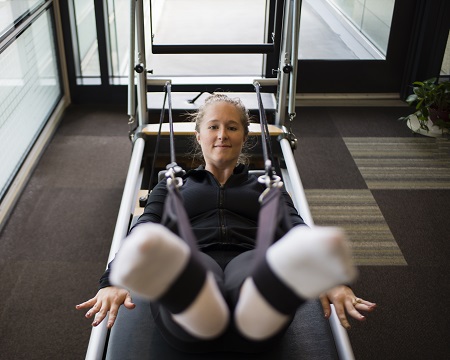 Trainer providing instruction to client on treadmill.