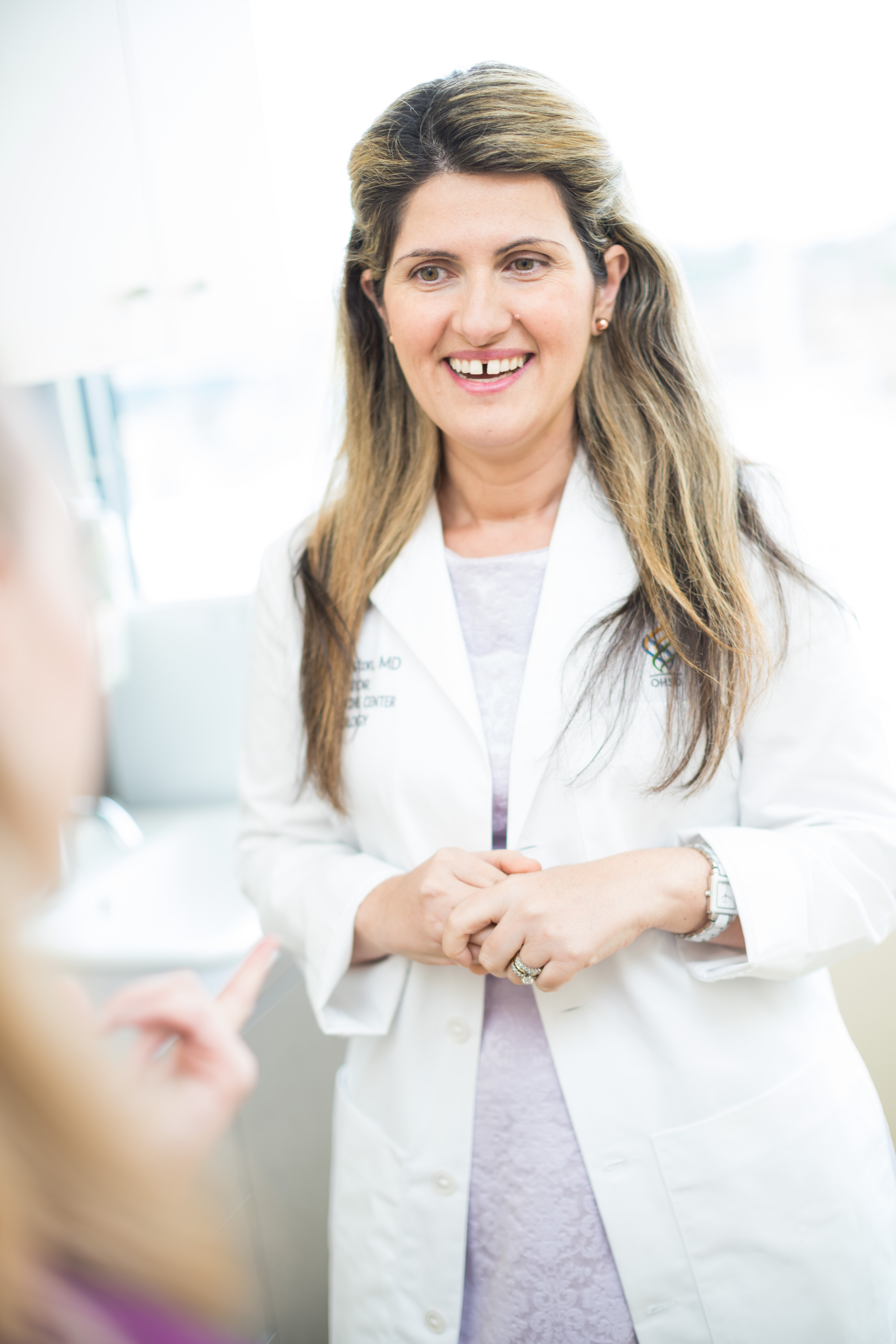 Dr. Juliette Preston in a white coat talking with a patient