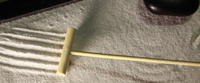 Photo of a zen garden, with small rake.