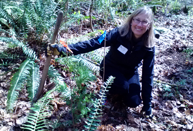 Ann Werner poses next to tree