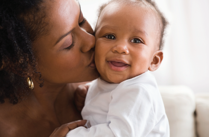 Mother kisses baby's cheek