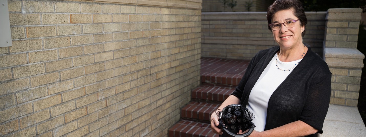 Dr. Melanie Fried-Oken sitting next to steps outside of an OHSU facility