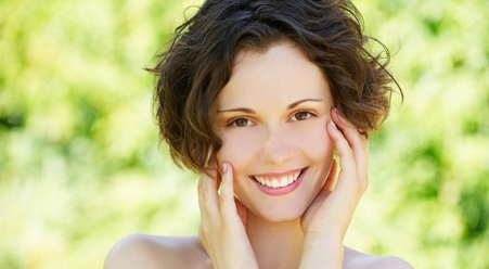 Smiling woman holding her face
