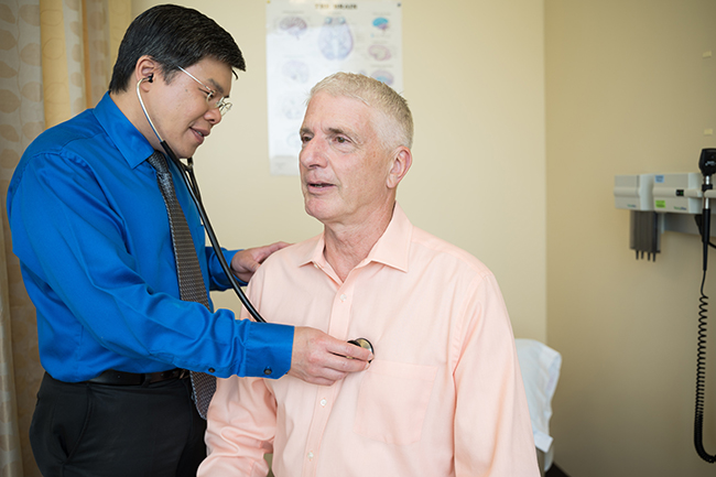 A doctor listening to a patient's heartbeat with a stethoscope.