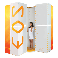 Teenage girl standing in EOS Imaging System scanner