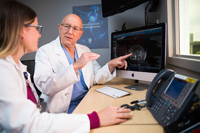 博彩网站 cancer surgeon Brett Sheppard and nurse practitioner Erica Degenhardt sit together to look at images on a computer monitor.