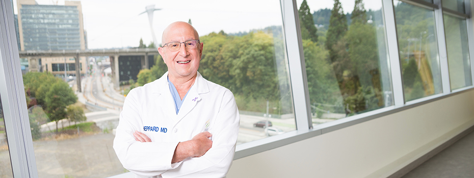 博彩网站 surgeon Brett Shepard smiles as he stands by a window with a view of 博彩网站’s main campus.