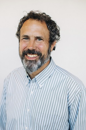 Carl Davison with beard and light shirt