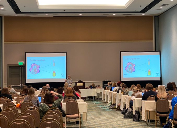 Woman gives live presentation at a conference.