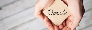 Hands holding out with a sign that says donate