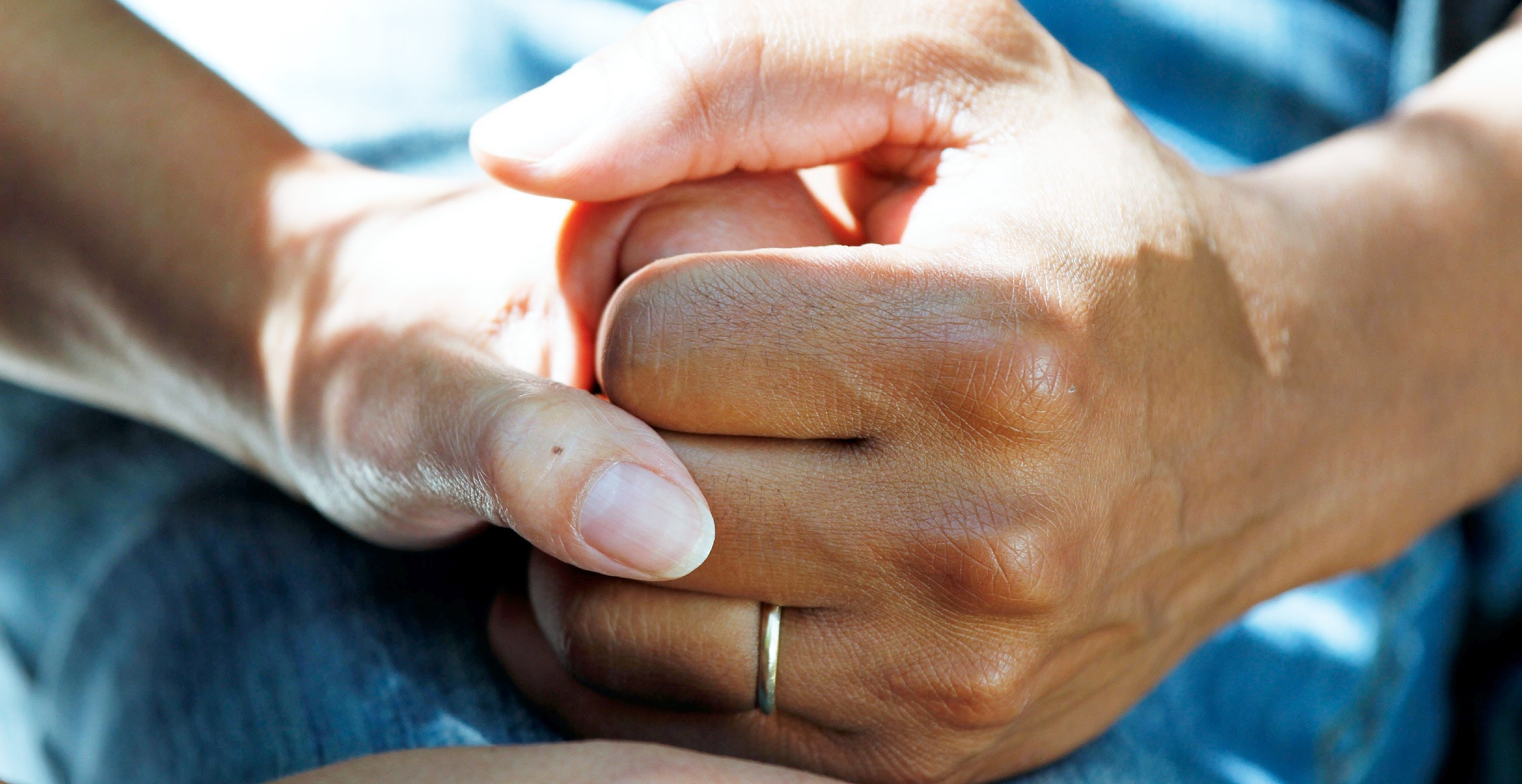 2 people holding hands in a supporting way
