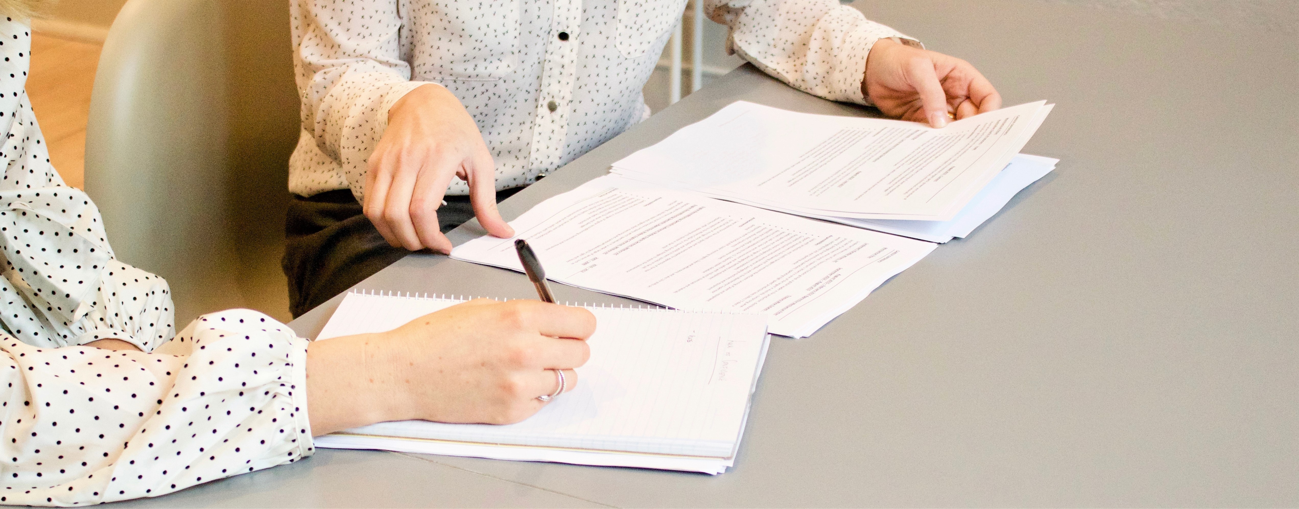 2 people looking over paperwork and taking notes