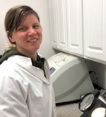 Photo of Natasha Cerruti, wearing a lab coat, in a research lab