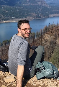 photo of Matt Hosanna sitting in front of a river