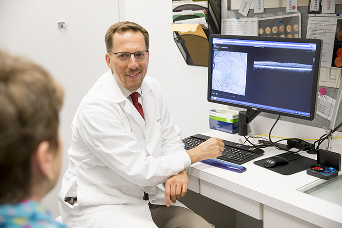 Dr. Lujan reviewing a retinal scan with patient