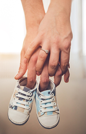 Hands holding baby shoes