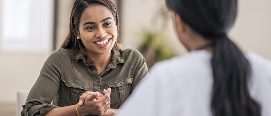 Patient sits at table talking with provider