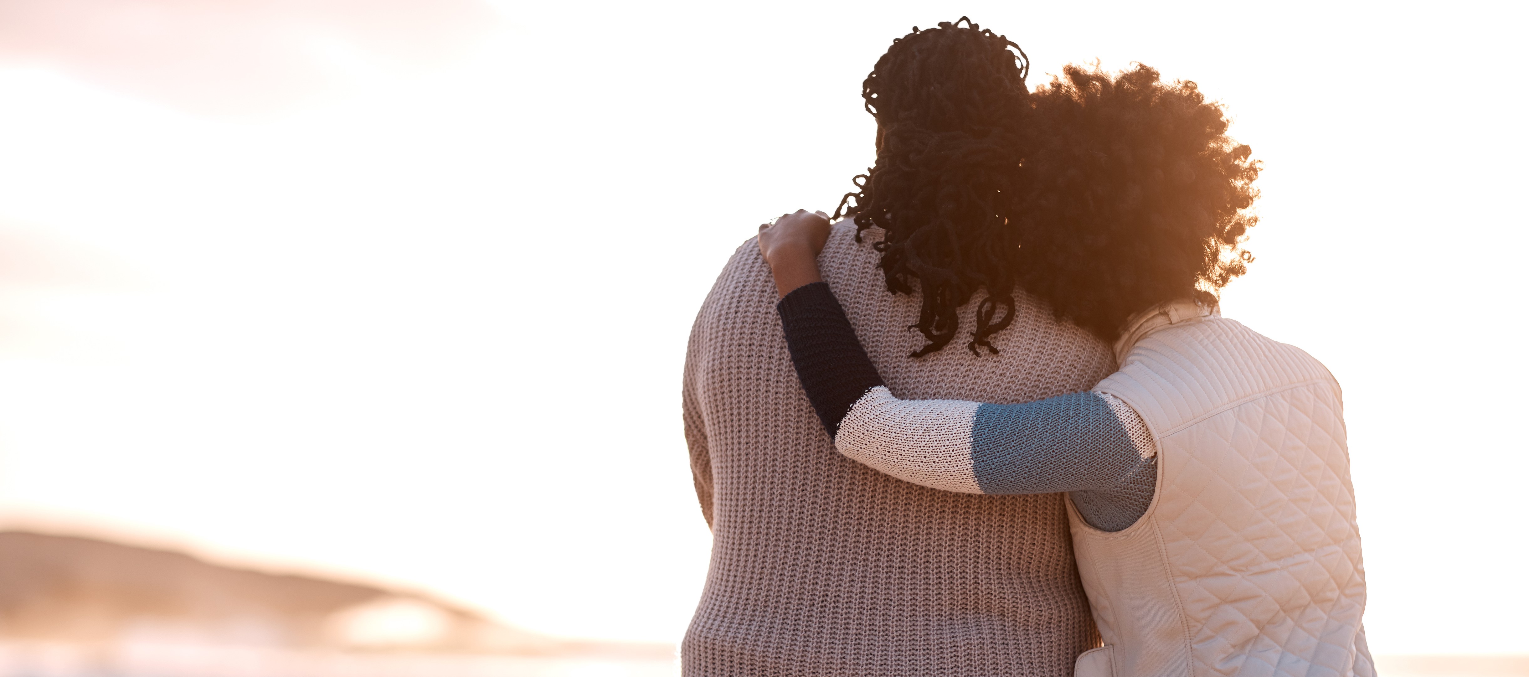 Two women hugging on the beach