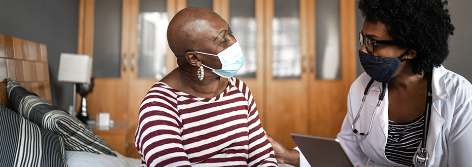 Doctor and patient in hospital room wearing masks