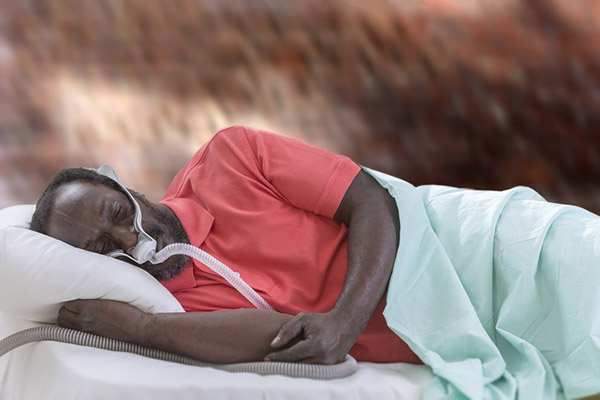 Stock photo of a person lying down while wearing a CPAP machine