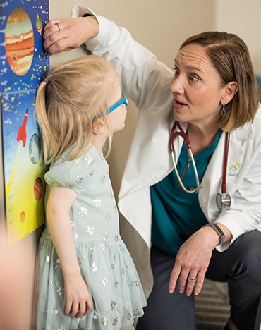 Dr. Kathryn Holmes measures patient Foxy Kusin's growth