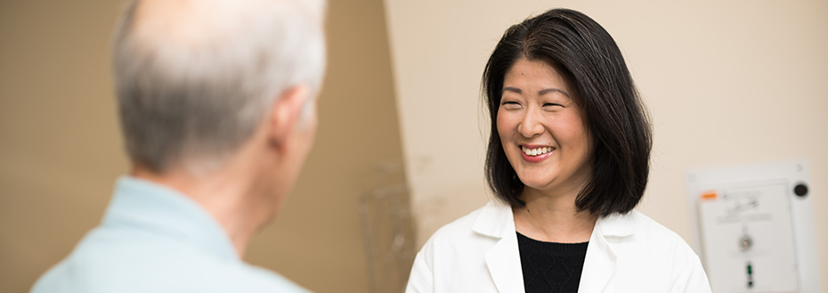 Dr. Jung smiles as she meets with a patient in an 博彩网站 exam room.