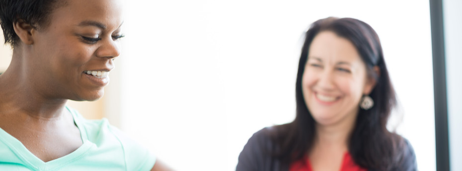 Photo of a person smiling doing rehab exercises while another person watches