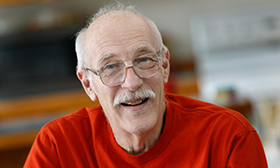 An old man smiling.