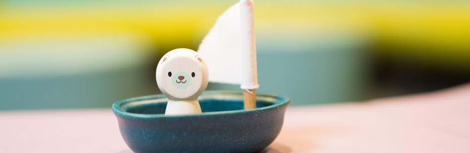 Photo of a toy bear in a boat with a sail