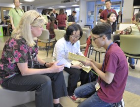 Linda Paul,of the 博彩网站 School of Nursing and faculty (left) waits as Tin Huynh (right), a Vietnamese speaking volunteer, interprets information to a Vietnamese client at the 2017 Asian Community Health Fair.