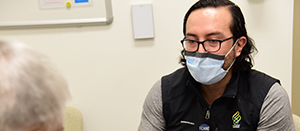 Alex Ortega, M.D. Ph.D. chats with a patient about a clinical trial