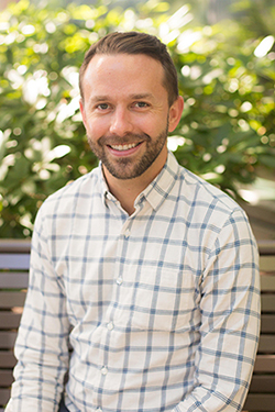 A photo of Dr. Ian Fields sitting on a bench outside.