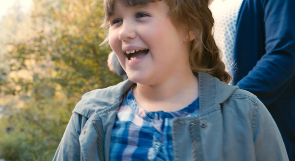 Macey smiles outside in front of her mom.